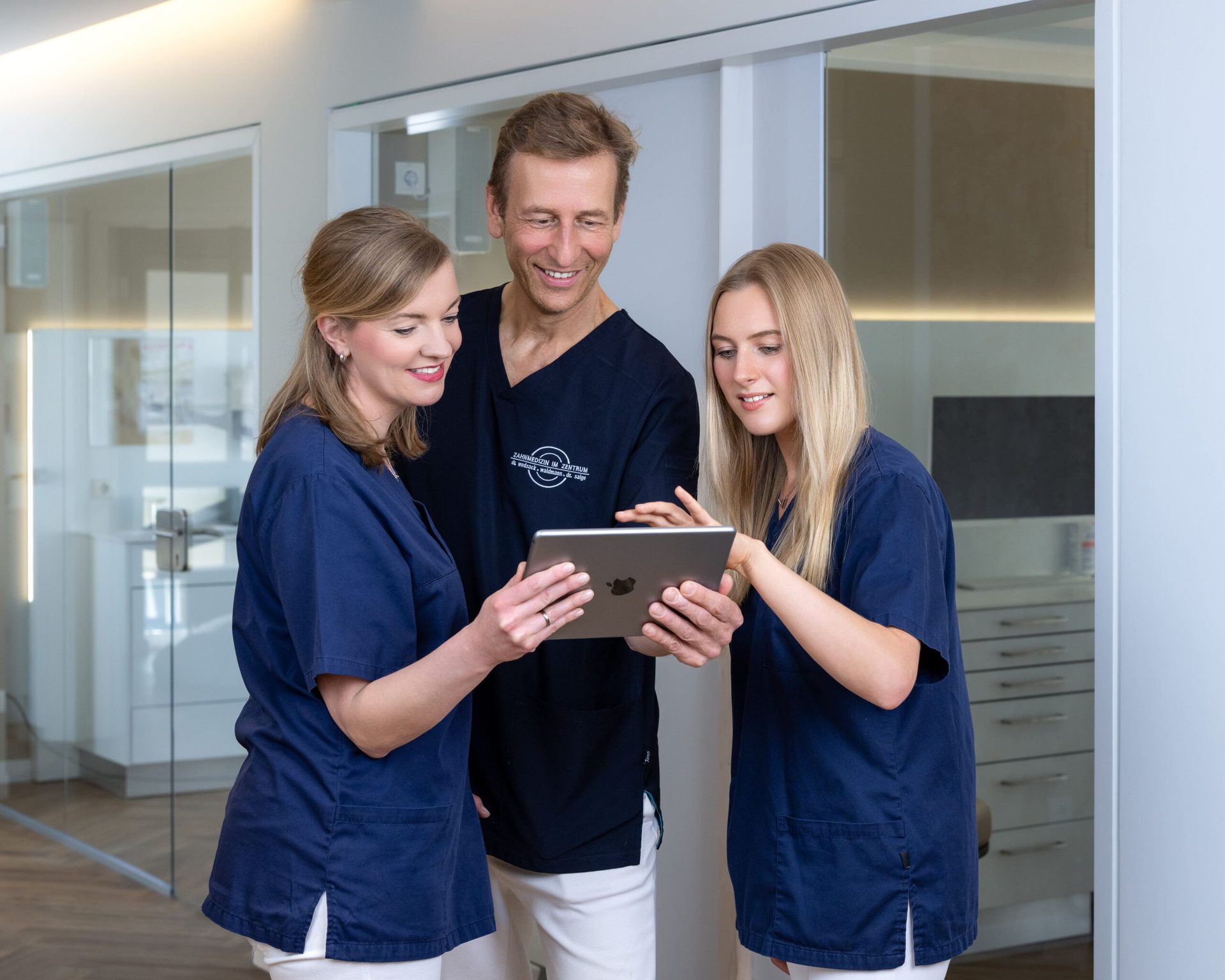 Drei Teammitglieder mit iPad im Flur